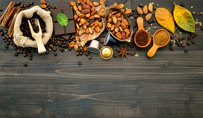 Coffee beans , cocoa beans ,coffee capsule ,dark chocolate bar and coffee powder on dark wooden background. Top view with copy space..