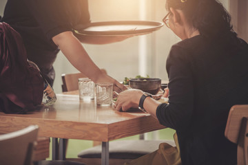 The girl is thinking of a menu for ordering food in a restaurant.