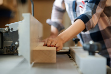 Closeup of carpenter woman at circular cutter