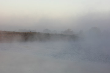 misty dawn on the river overlooking the island trees