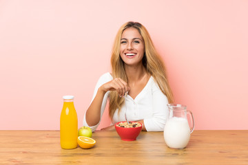 Young blonde woman having breakfast milk