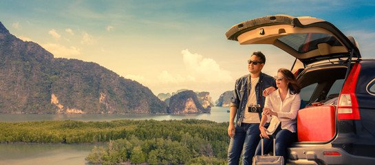 Asian couple Man with vintage camerra and woman sitting on back of car  travel to mountain and lake in holiday with car road trip
