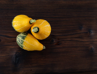 Beautiful, bright vegetables-pumpkins yellow and green on a beautiful natural wooden background.
