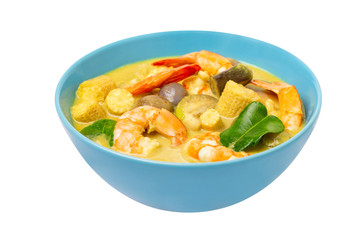 Closeup plate of thailand green curry soup with coconut milk and shrimps isolated at white background.