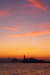 Fototapeta na wymiar Seascape at sunset. Lighthouse on the coast. Seaside town of Turgutreis and spectacular sunsets