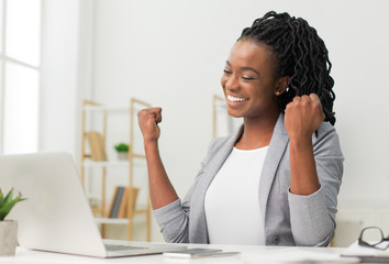 Black Lady Celebrating Business Success Sitting At Laptop In Office
