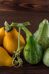 Beautiful, bright vegetables-pumpkins yellow and green on a beautiful natural wooden background.