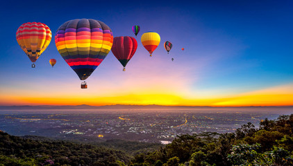 Hot air balloons flying over Doi Suthep National Park at sunrise in Chiang Mai Province, Thailand.