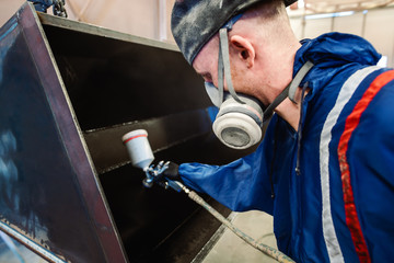 Varnisher in industrial metal factory