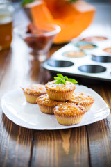 baked sweet pumpkin muffins with dried apricots inside,