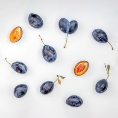 Plum Pattern. Blue plums on white background. Top view, flat lay.