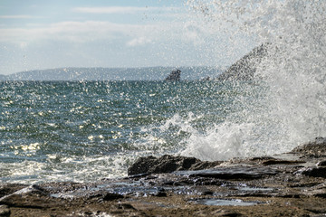 Waves breaking over sea wall barrier