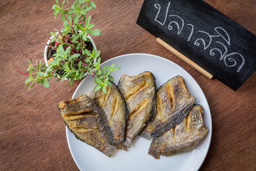 Thai food fried salid fish cut in stripes.  Trichogaster pectoralis on wooden background