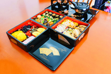 Obraz na płótnie Canvas 日本の正月イメージ：年末に家庭で作られ新年に家族揃って食べる御節料理と重箱：受け継がれる伝統・風習
