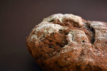 Whole grain rye bread, isolated on dark background. Closeup