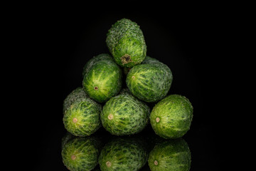 Group of six whole fresh pickling cucumber pyramid isolated on black glass