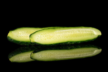 Group of two halves of fresh green pickling cucumber isolated on black glass