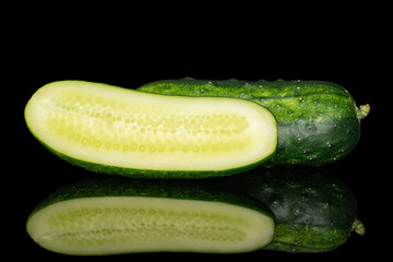 Group of one whole one half of fresh green pickling cucumber section isolated on black glass