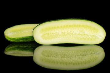 Group of two halves of fresh green pickling cucumber section isolated on black glass