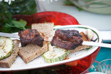 Served on a plate shashlik and baked vegetables, picnic outside, selective focus