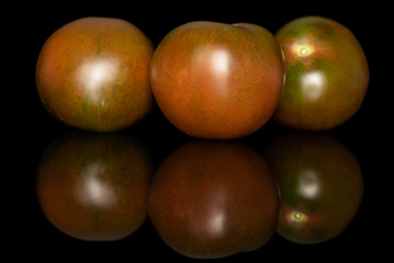 Group of three whole fresh green red tomato isolated on black glass