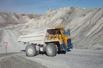 Heavy mining dump truck in a limestone quarry close-up. Mining industry. Heavy equipment.