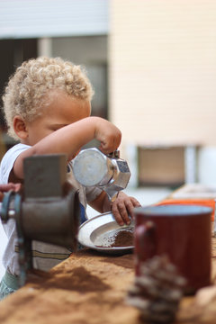 Little boy playing with coffee grounds, dramatic play, kitchen