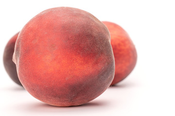 One whole fresh fuzzy peach on wooden square plate isolated on white background