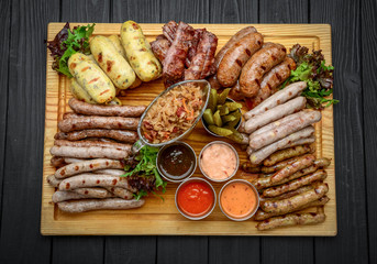 Grilled sausages with glass of beer on a wooden table