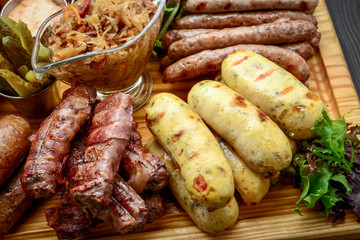 Grilled sausages with glass of beer on a wooden table
