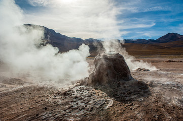 Detail of active geyser formation at El Tatio, Atacama, Chile. Active geysers comes out of the ground. Hot vapor erupting activity, thick flume of steam. Tourists watching geyser in the Los Géiseres 