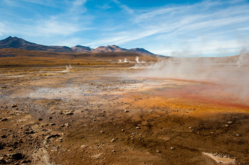 El Tatio, Atacama, Chile. Active geysers comes out of the ground. Hot vapor erupting activity, thick flume of steam. Tourists watching geyser in the Los Géiseres del Tatio area in the Atacama Desert