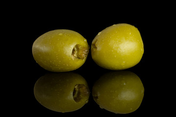 Fototapeta na wymiar Group of two whole pitted green olive isolated on black glass