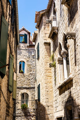 Characteristic Dalmatian stone houses, stone facades in the narrow street, summer holidays in Split, Dalmatia, Croatia 