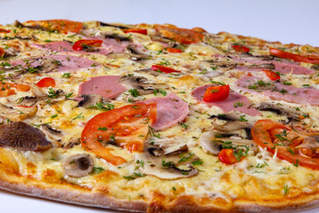 Pizza closeup background with ham, beef and tomatoes