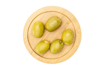 Group of five whole pitted green olive on bamboo plate flatlay isolated on white background
