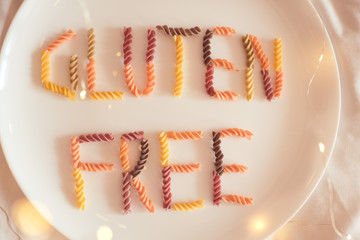 Gluten free words made with pasta on white plate close up. Healthy lifestyle. Selective focus.