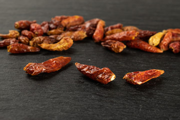 Lot of whole dry red chili pepper peperoncino on grey stone