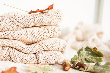 Knitted wool sweaters. Pile of knitted winter, autumn clothes knitwear.