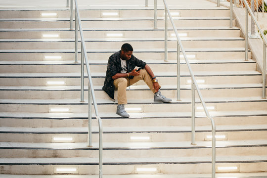 Man with mobile phone sitting on stairs