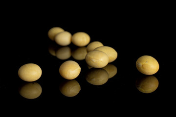 Lot of whole raw yellow soya bean isolated on black glass