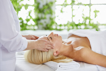 Beautiful woman with closed eyes getting a massage in the spa s