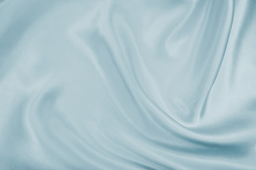 Delicate satin draped fabric of blue color texture for festive backgrounds