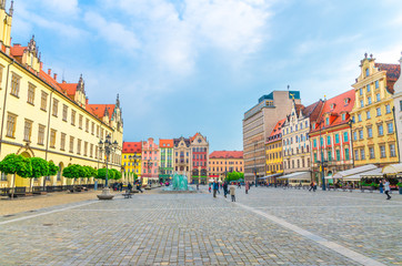 Fototapeta na wymiar Row of colorful traditional buildings with multicolored facades, New City Hall, glass fountain on Rynek Market Square in old town historical city centre of Wroclaw, Poland