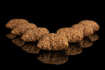 Group of seven whole crispy brown cereal pillow isolated on black glass