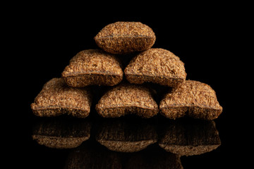 Group of six whole crispy brown cereal pillow in pyramid isolated on black glass