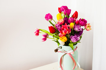 Bouquet of colorful tulips in white can