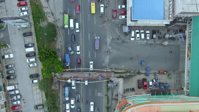 Top down view of people crossing the footbridge over the traffic highway in town