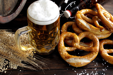 Beer barrel with beer mug and pretzels on wooden background