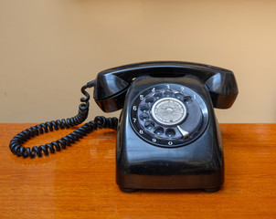 Vintage black telephone isolated on wood table.